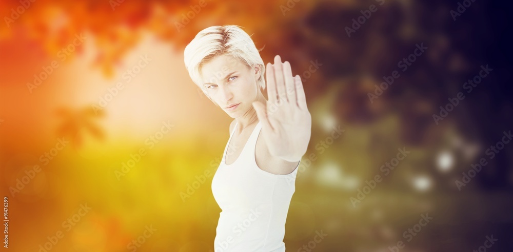 Composite image of angry pretty blonde showing her hand 