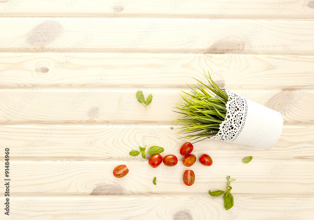 Light wood background. basil and tomatoes