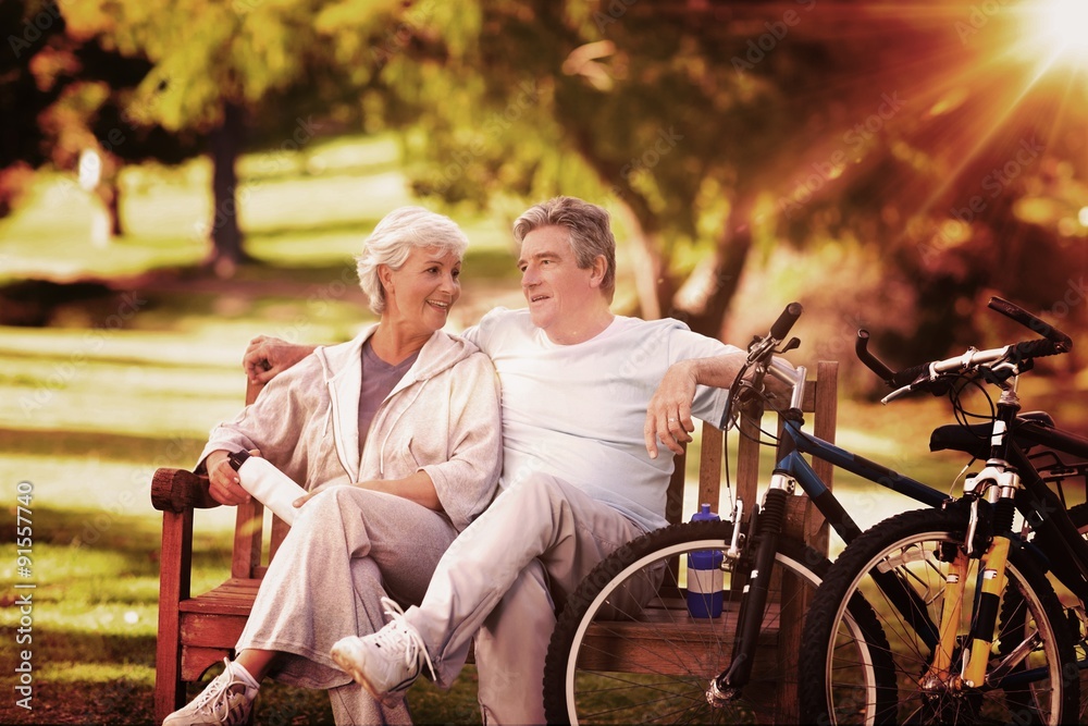 Composite image of elderly couple with their bikes