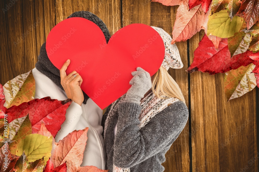 Composite image of couple behind red heart