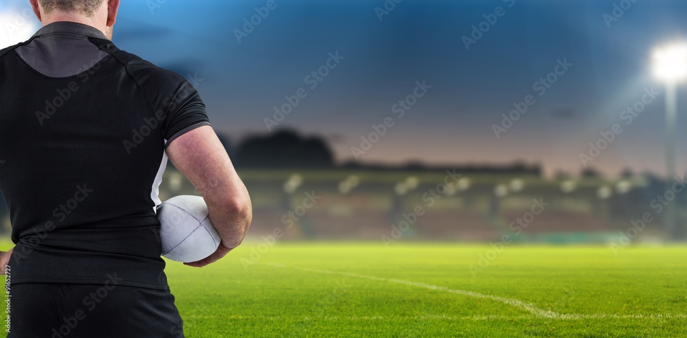 Composite image of rugby player holding the ball