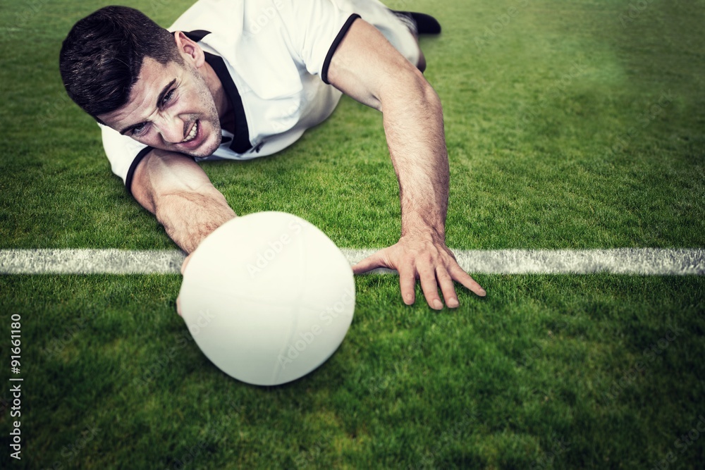 Composite image of man lying down while holding ball