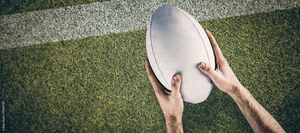 Composite image of a rugby player posing a rugby ball