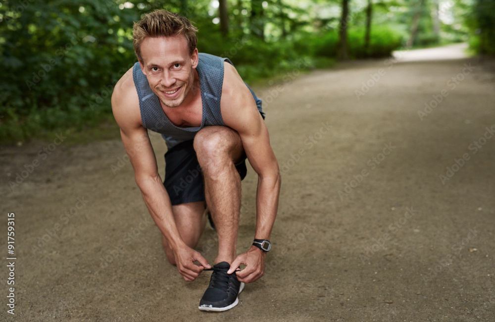 Smiling Fit Man Fixing his Shoelace at the Park