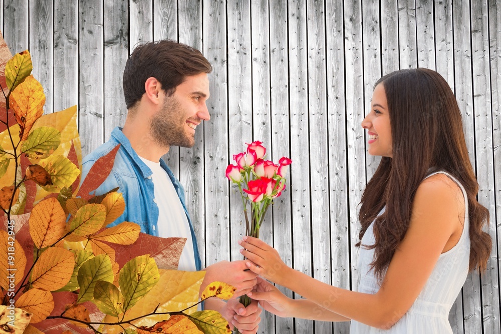 Composite image of happy hipster giving his girlfriend roses