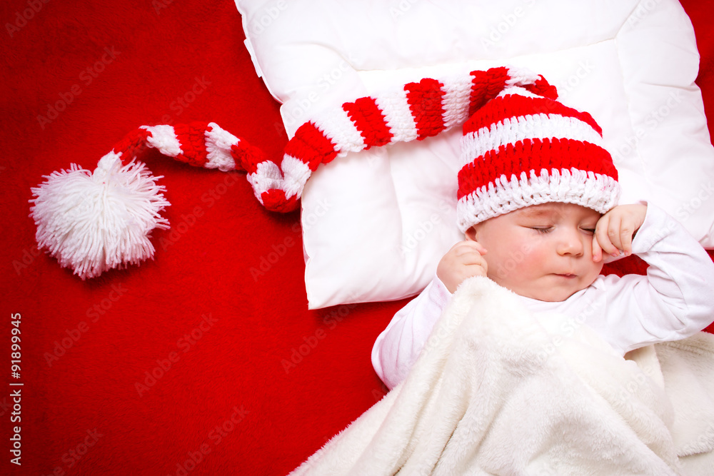 Sleepy baby on red blanket