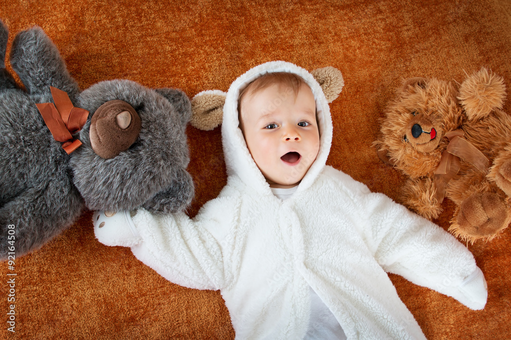 Little baby in bear costume with plush toys