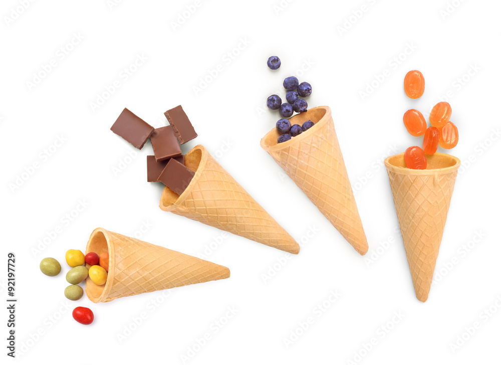 waffle cones with chocolate, candy and berries