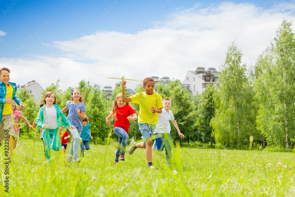 African kid with airplane toy and children behind