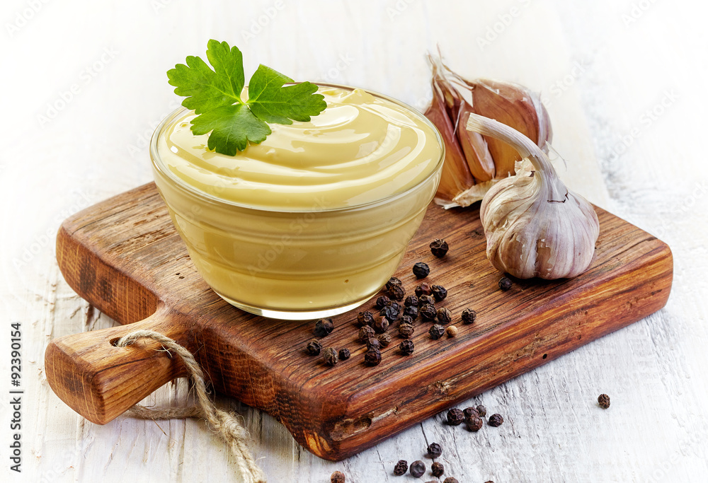 Mayonnaise sauce on wooden cutting board