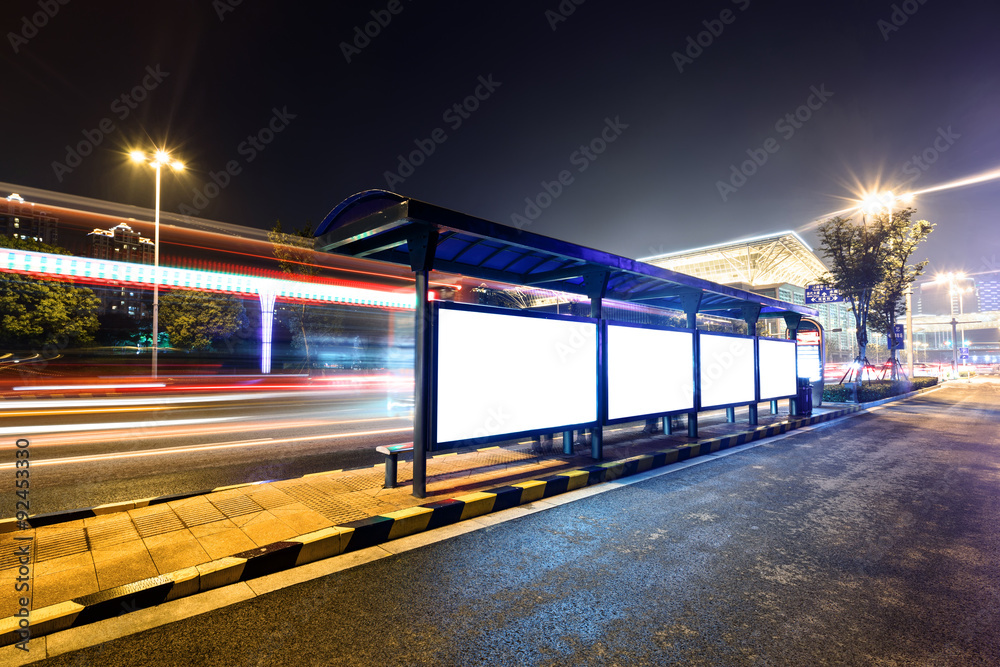 bus station next to a road at night