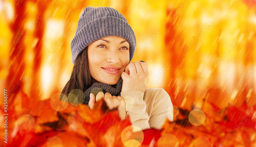 Composite image of attractive brunette looking up wearing warm