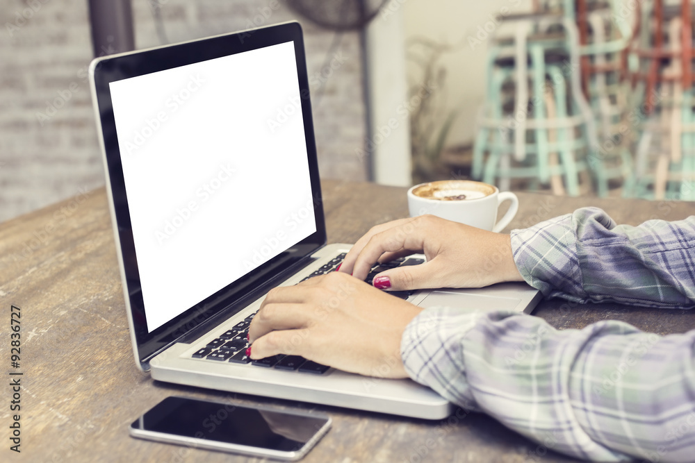 woman typing on a laptop with cell phone and coffee, mock up