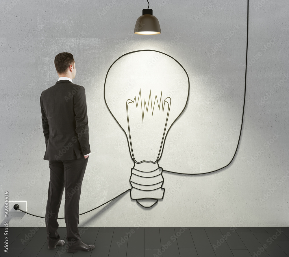 Man looking to the light bulb concept on the wall