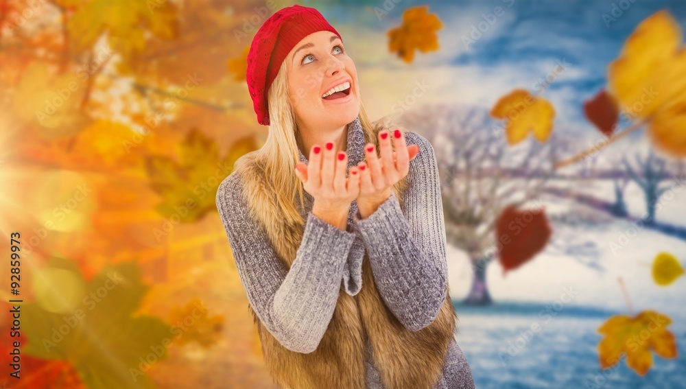 Composite image of blonde in winter clothes with hands out