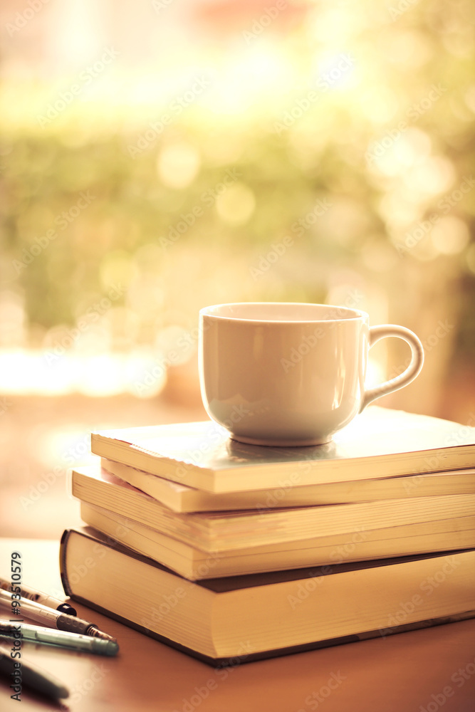 selective focus of white coffee cup and  books stacking 