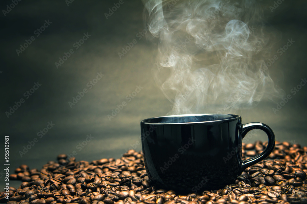 still life of warm black cup of coffee on  roasted coffee beans