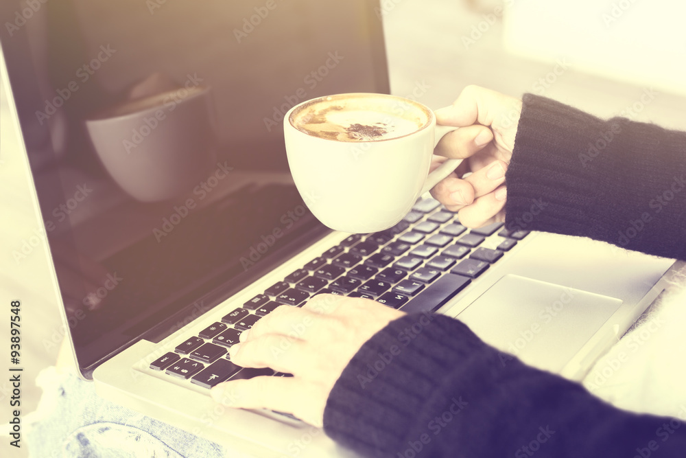 Girl with coffee cup and laptop