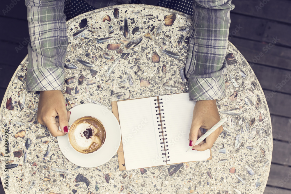 Girl with cup of coffee and diary