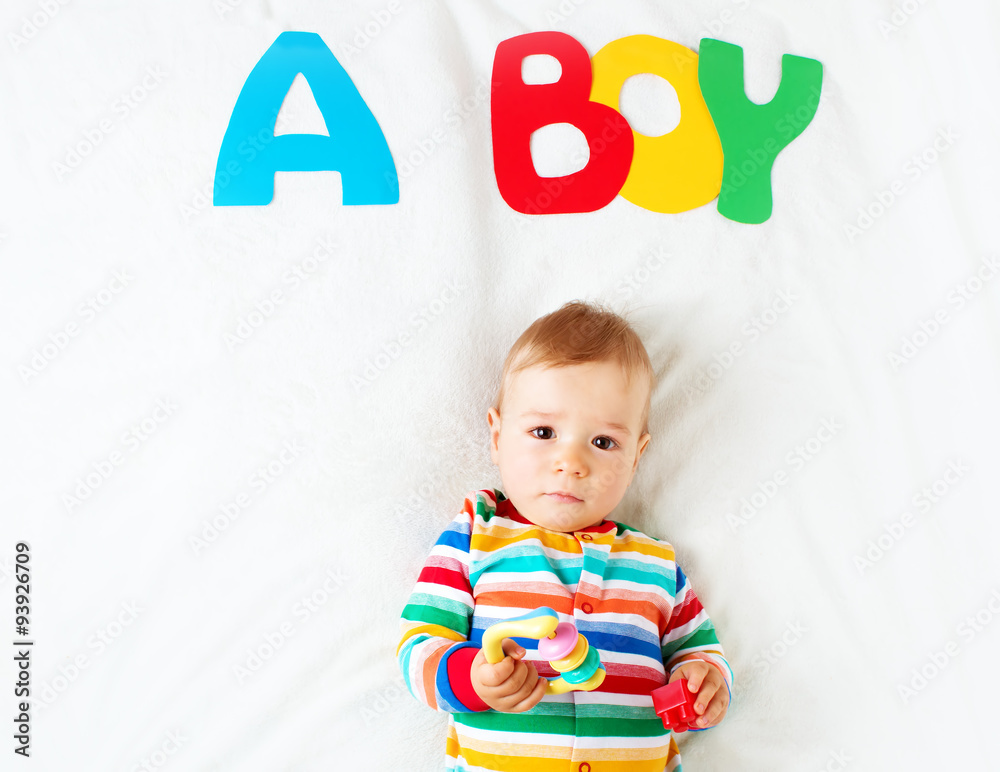 Baby boy lying on the blanket with letters above