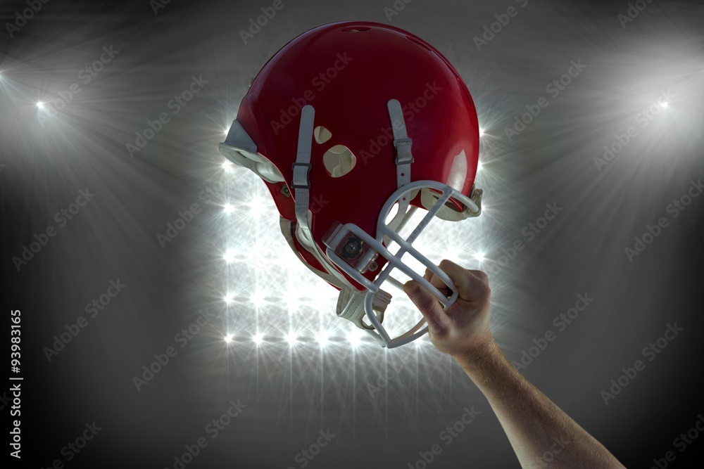 American football player holding up his helmet