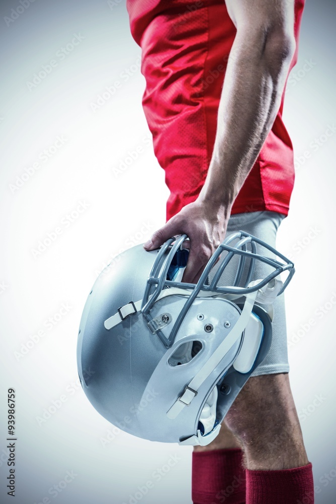 American football player holding helmet