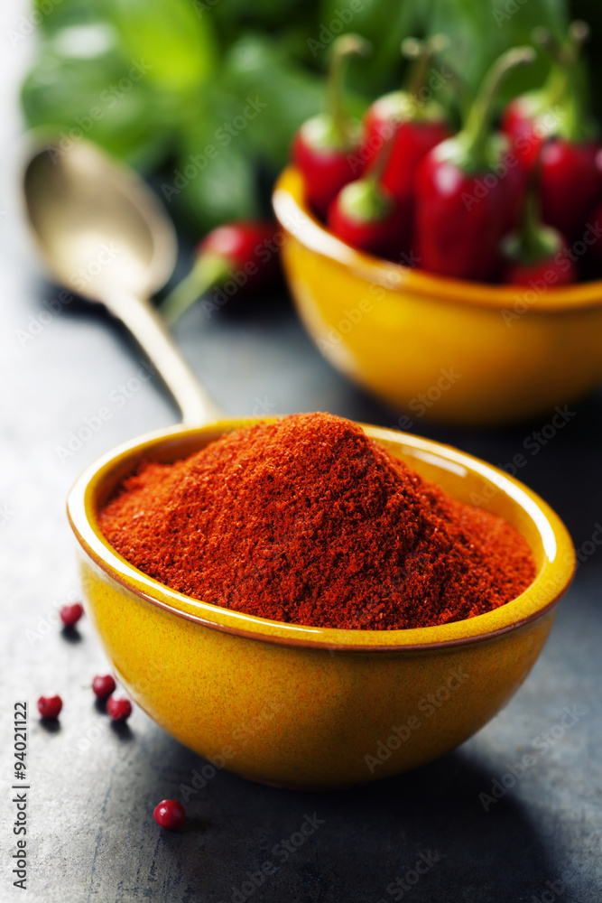 Paprika in a bowl and hot chili peppers