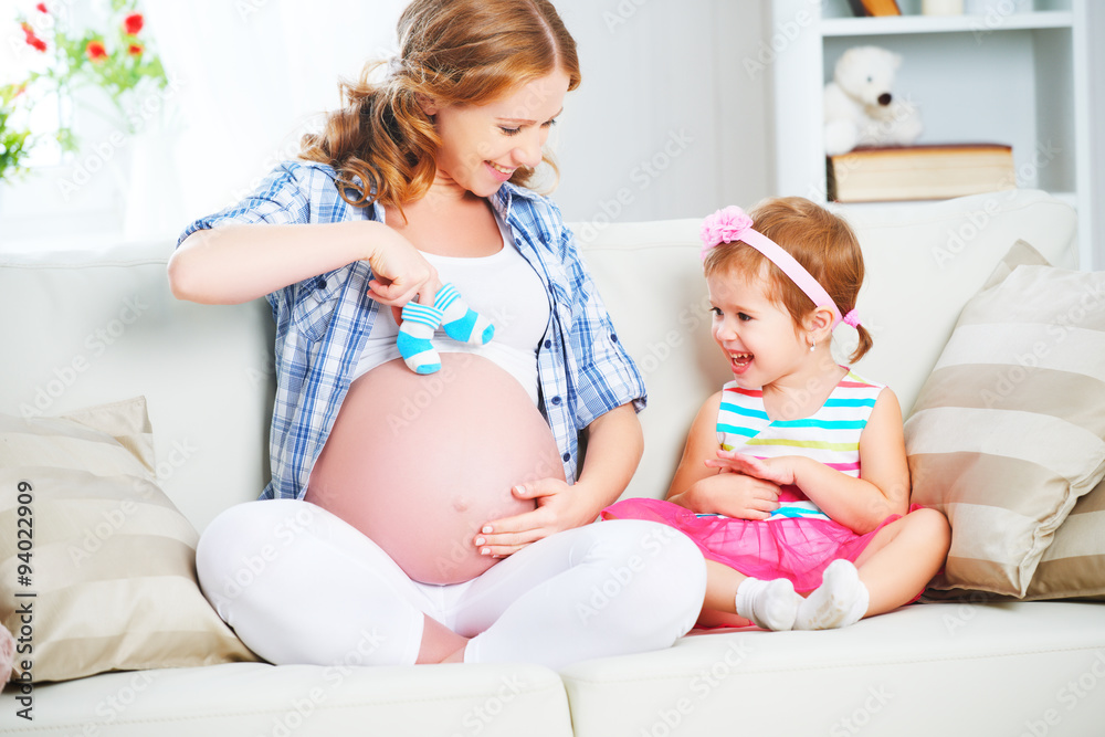 happy family pregnant mother and child daughter preparing clothi