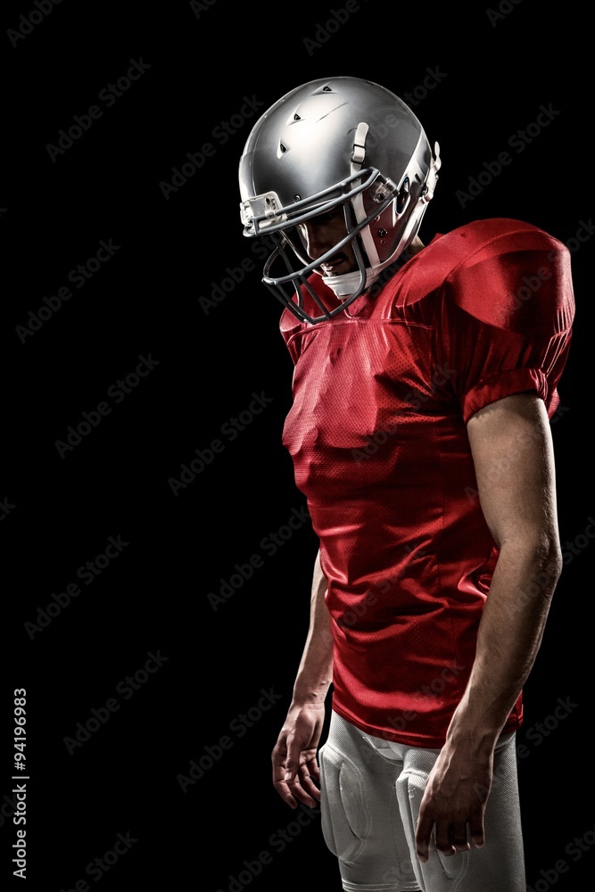 Composite image of american football player looking down