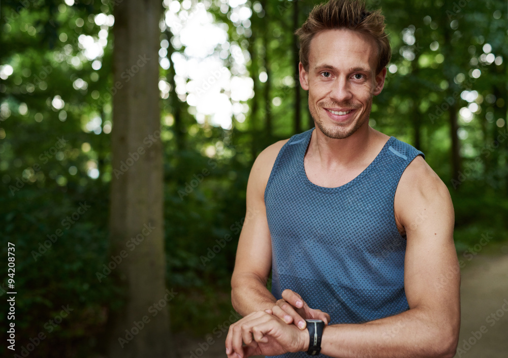 Muscular athlete setting his stopwatch