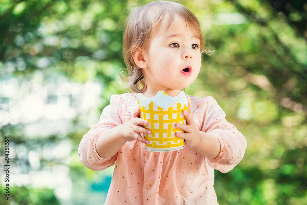 Surprised toddler girl playing outside