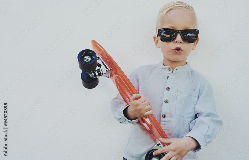 Cute hipster little boy with a skateboard