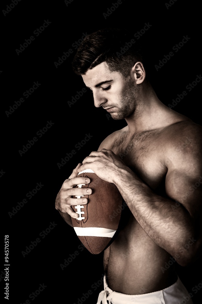 Composite image of shirtless rugby player holding the ball