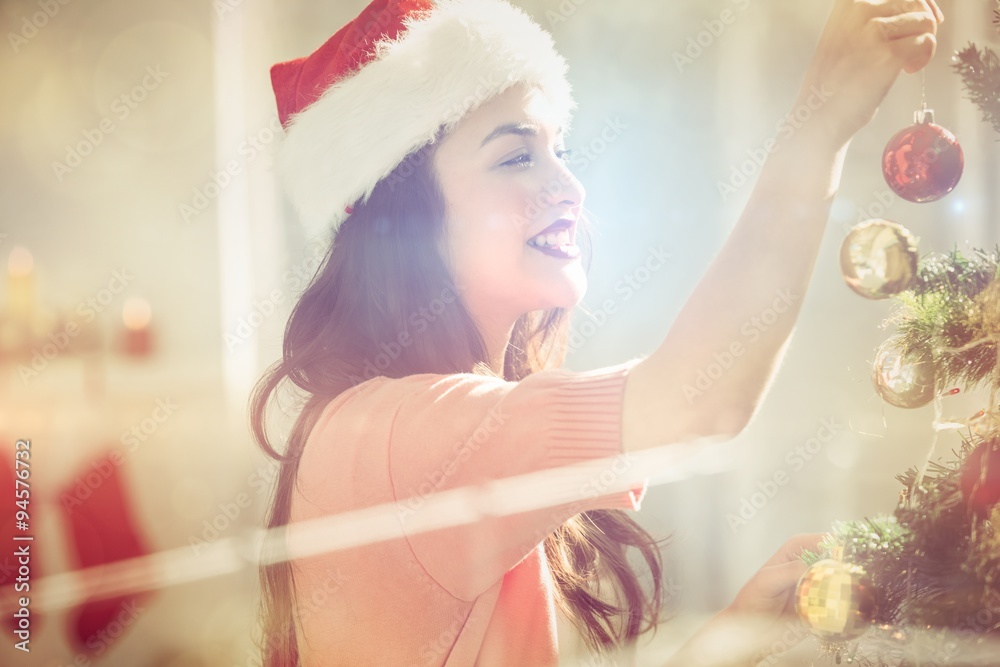 Happy brunette decorating a christmas tree