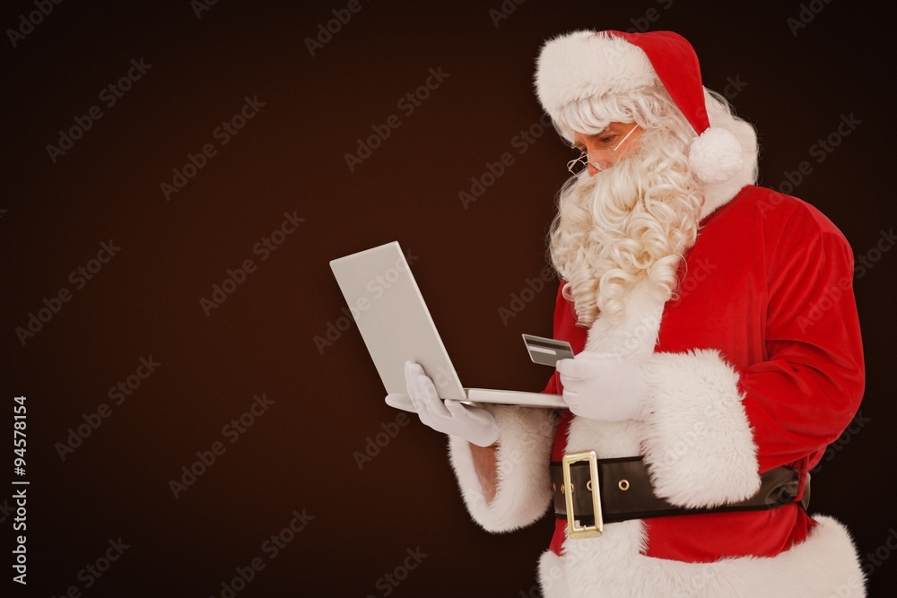 Composite image of santa claus shopping online with laptop 