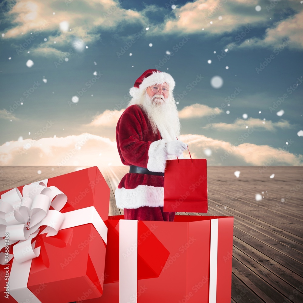 Composite image of santa standing in large gift