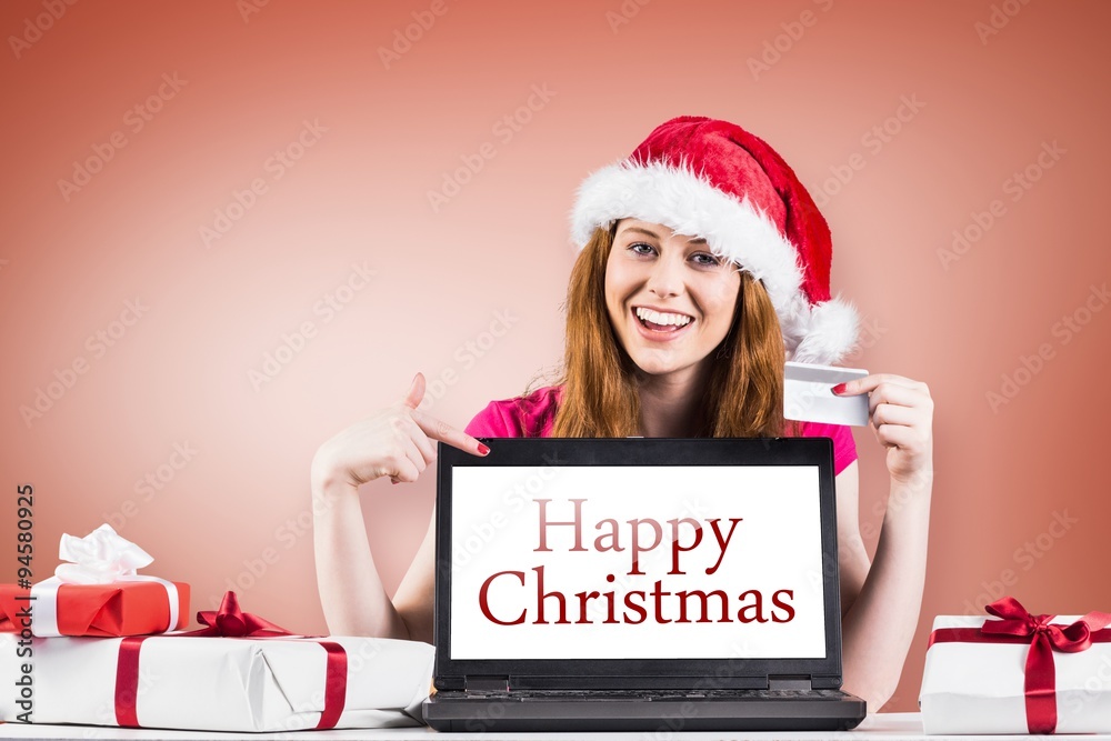 Composite image of festive redhead shopping online with laptop