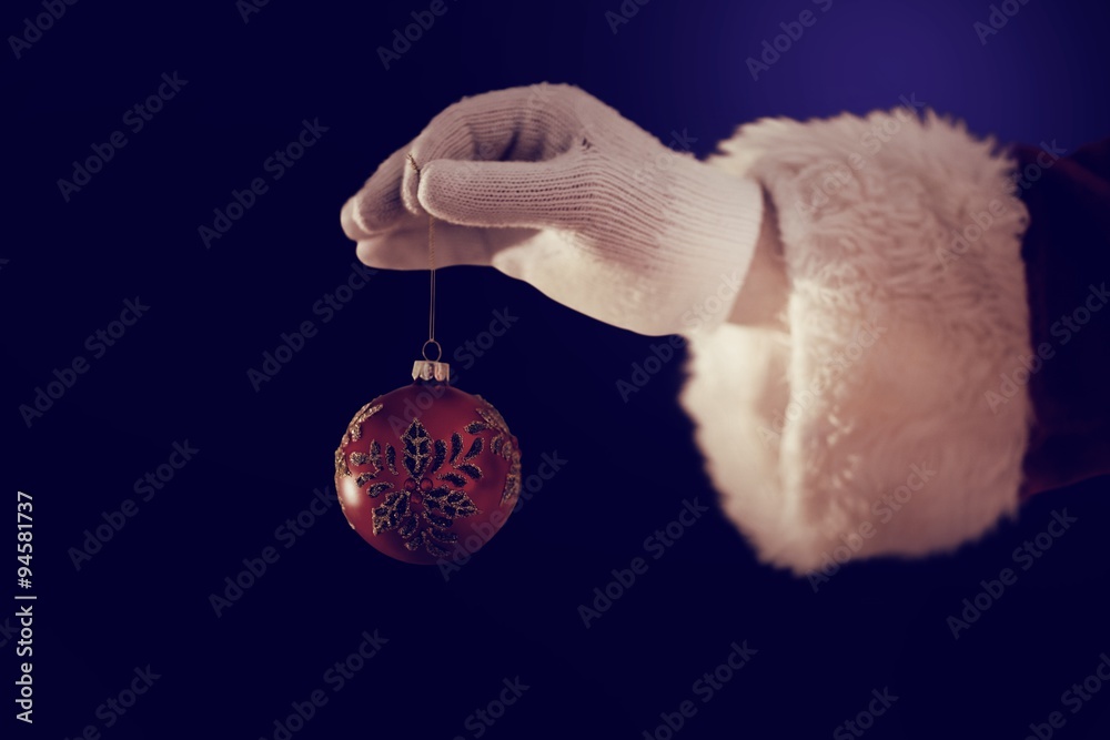 Santas hand is holding a Christmas bulb 