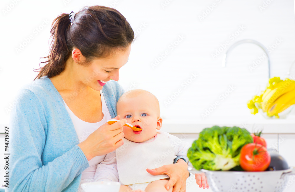 母亲用勺子喂她的女婴。婴儿食品