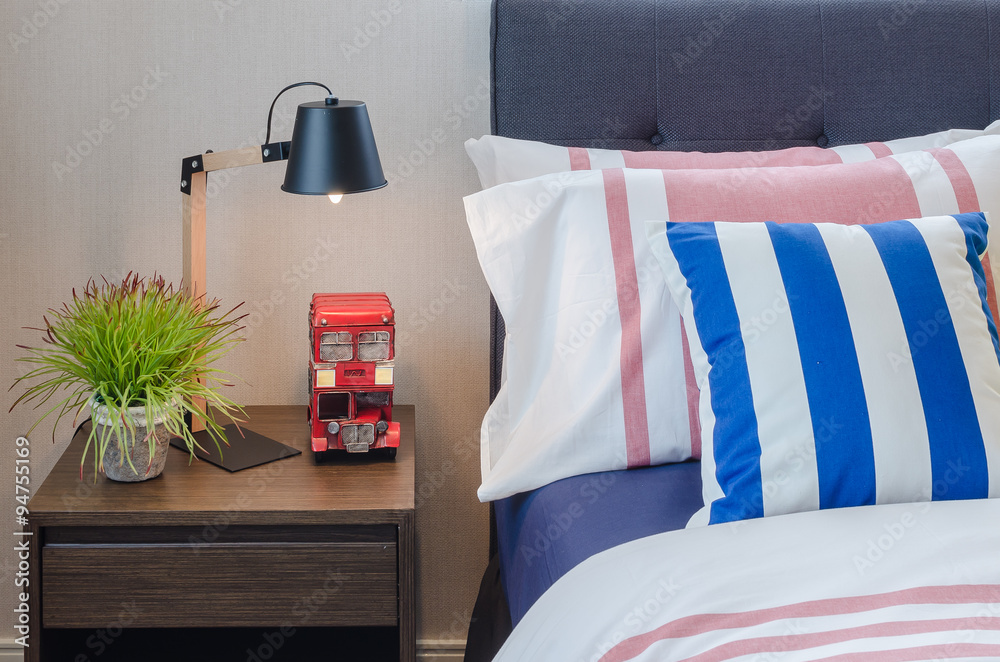 modern bedroom with colorful pillows on bed and modern black lam