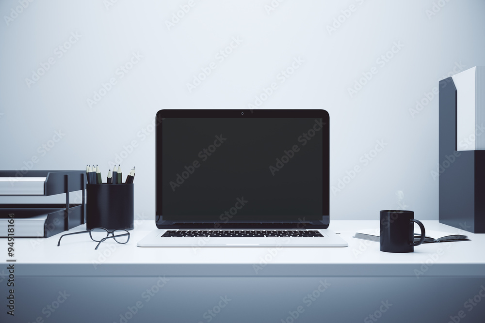 Blank screen of laptop on the table with glasses and cup of coff