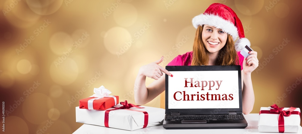 Composite image of festive redhead shopping online with laptop