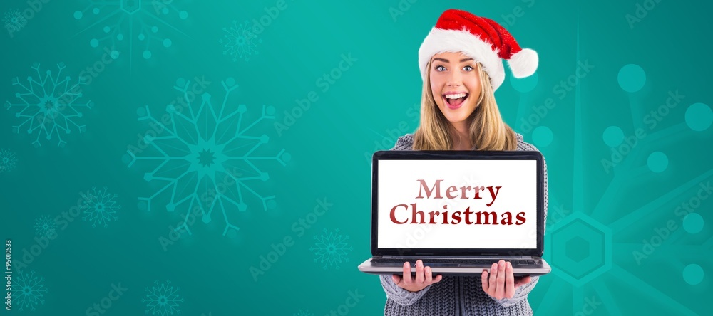 Composite image of festive blonde holding a laptop