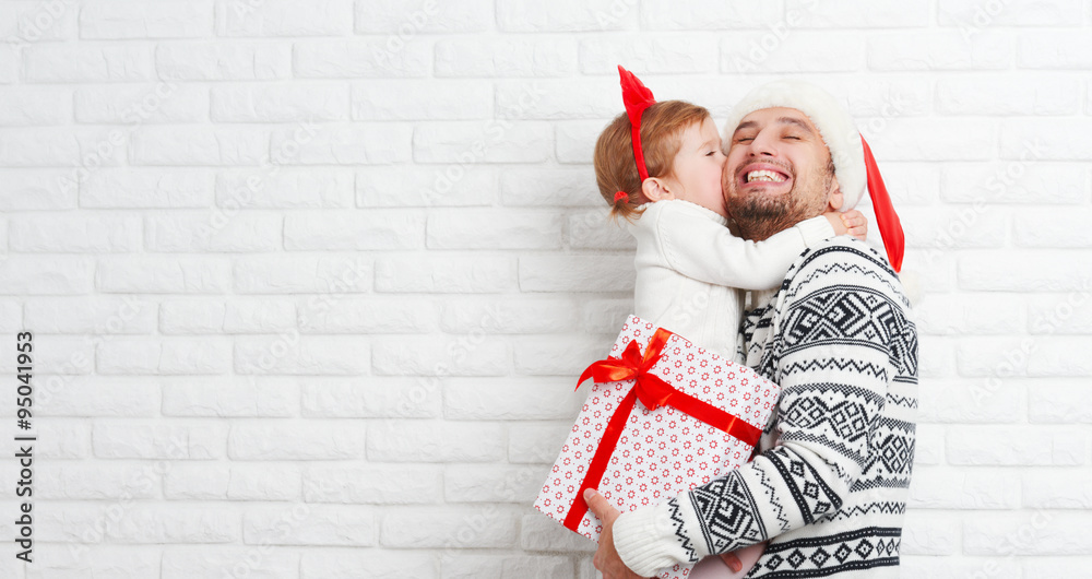 Happy family father and child with gift in Christmas kiss