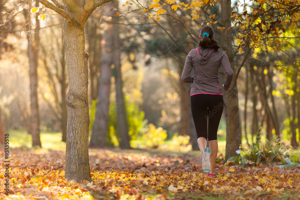 Female fitness model training outside and running.