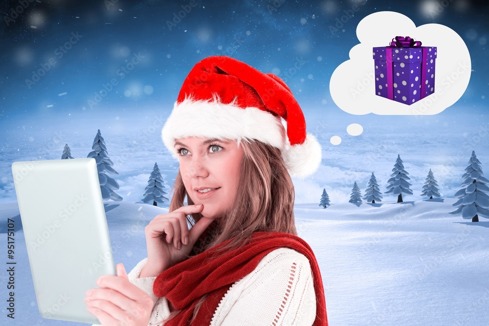 Composite image of festive blonde looking at tablet pc