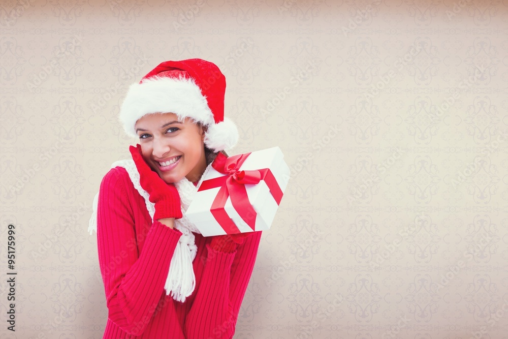 Composite image of festive brunette holding gift