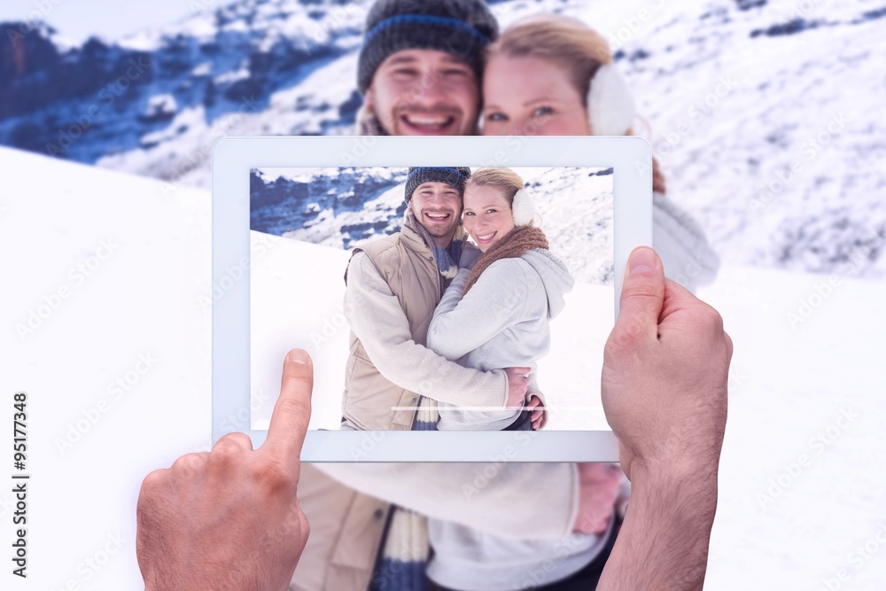 Composite image of hand holding tablet pc