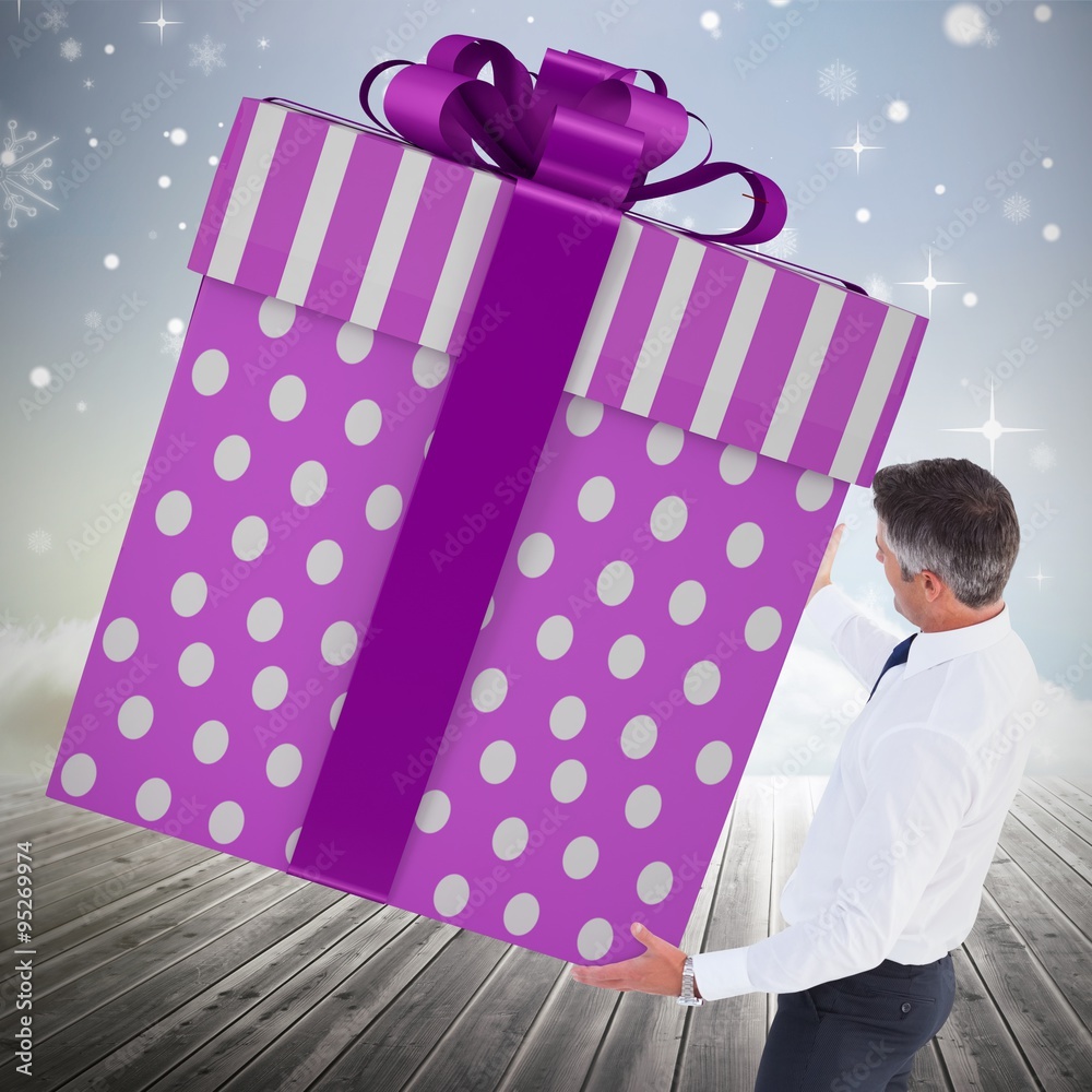 Composite image of stylish man with giant gift