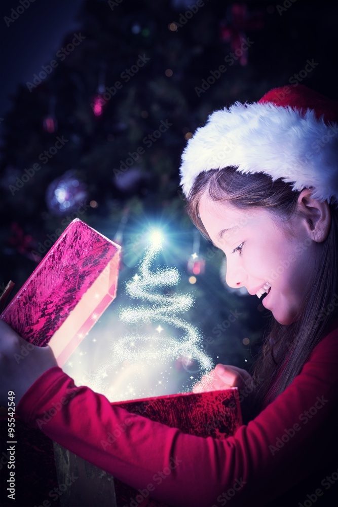 Composite image of little girl opening a magical christmas gift